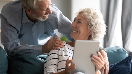 couple looking at tablet and smiling for some reason